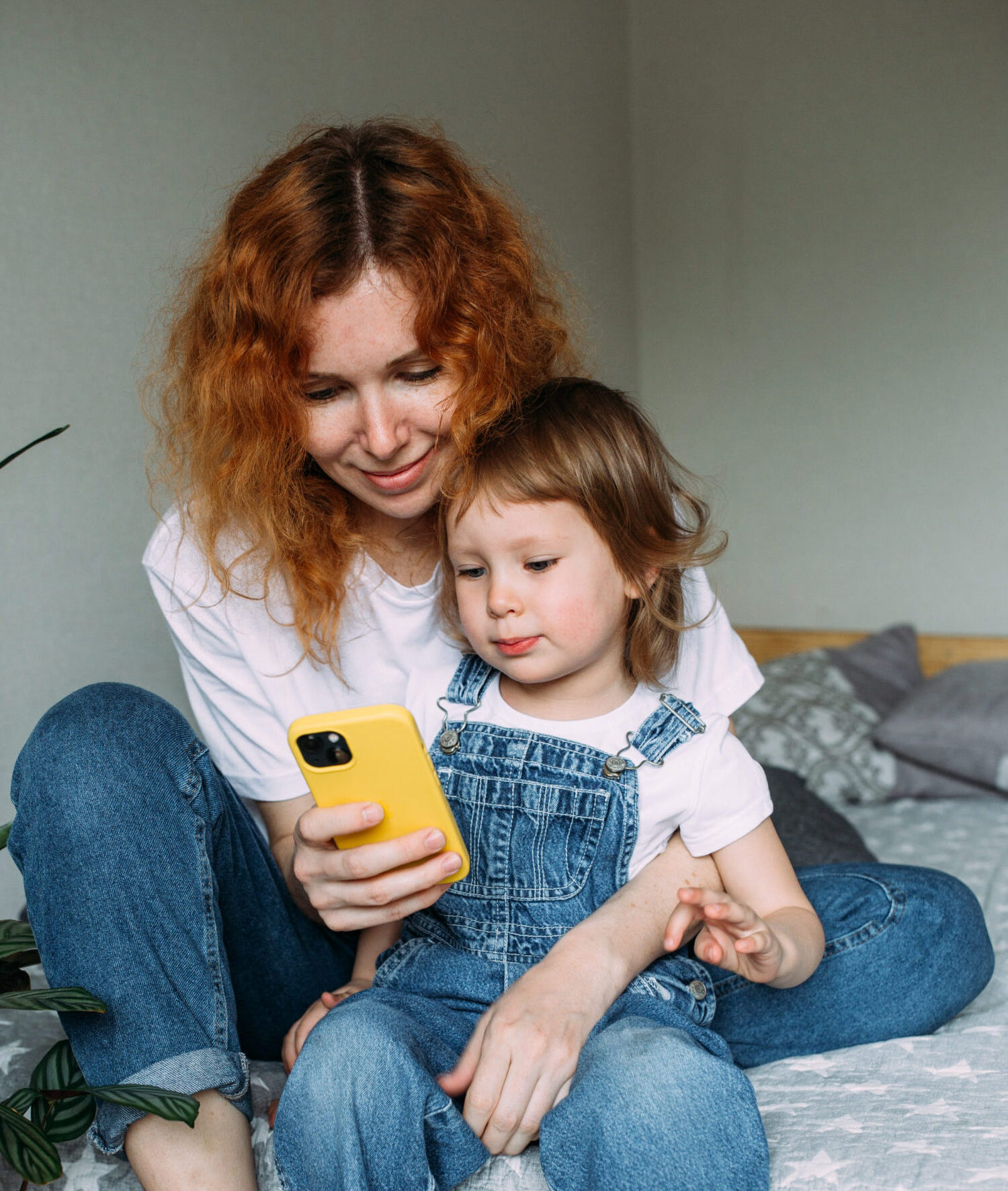 Ouder en kind gebruiken samen een smartphone om iets te bekijken