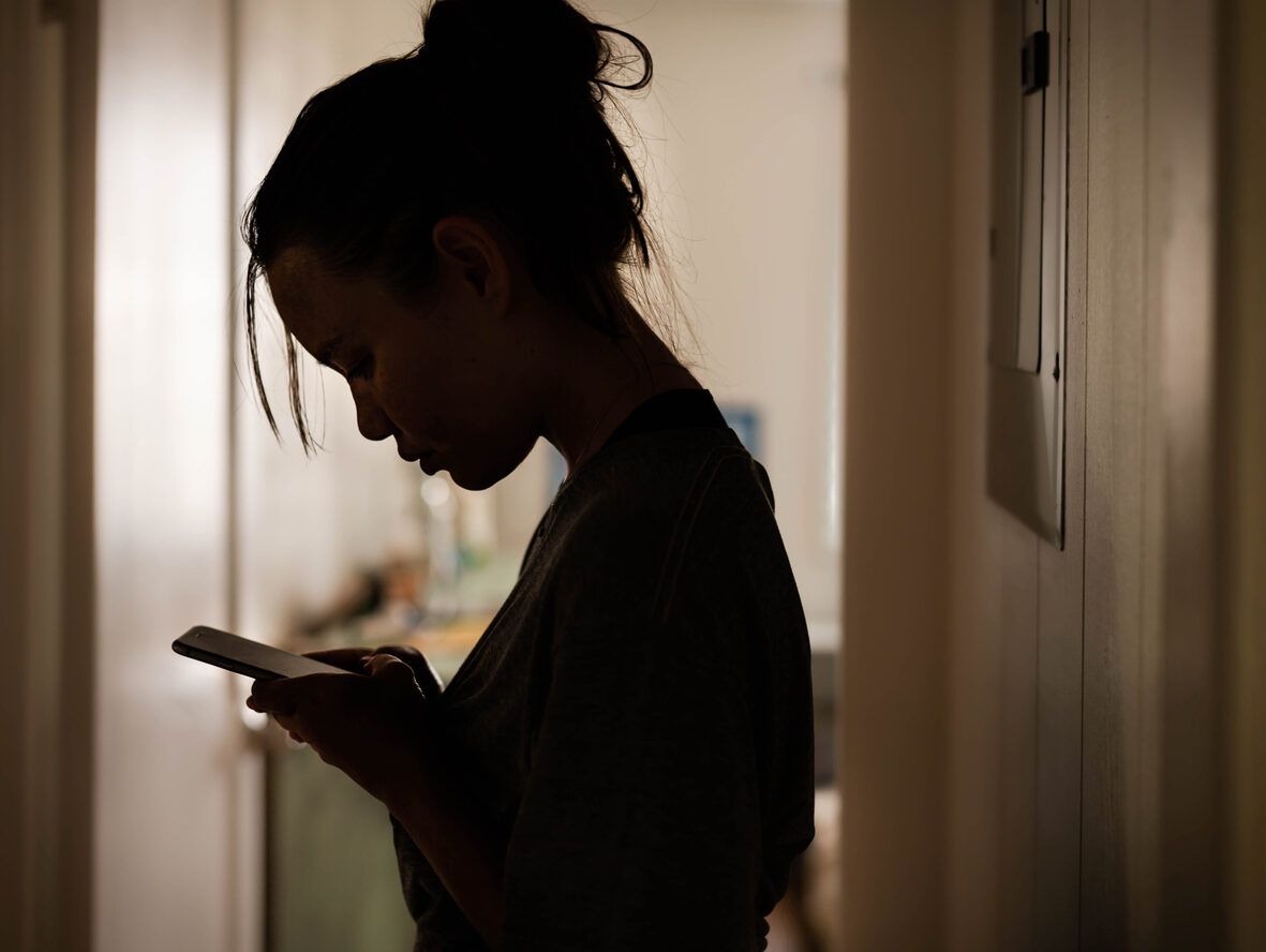 vrouw kijkt op telefoon in het donker