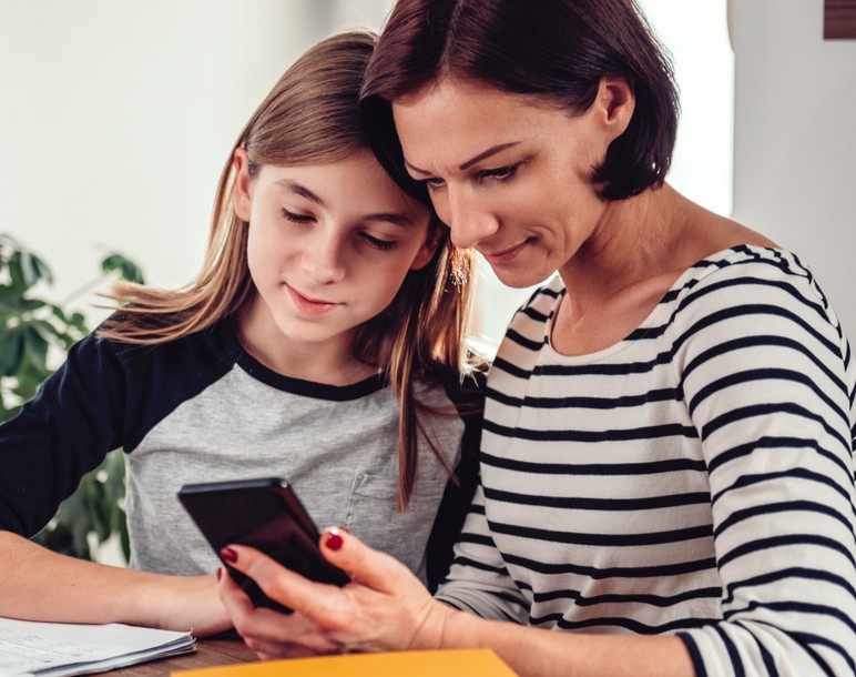 moeder en kind kijken naar mobiele telefoon