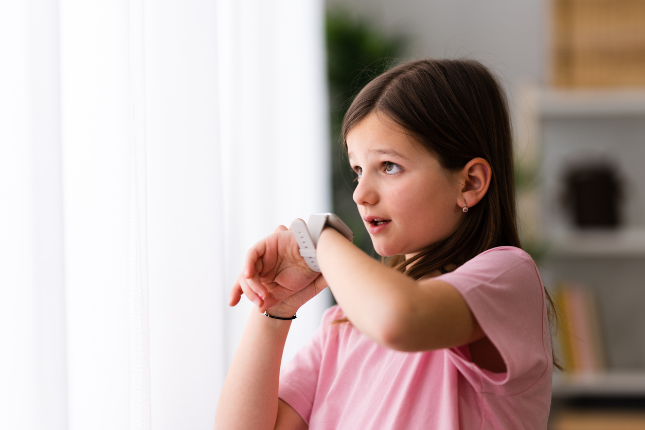 Meisje praat via de smartwatch om haar pols.